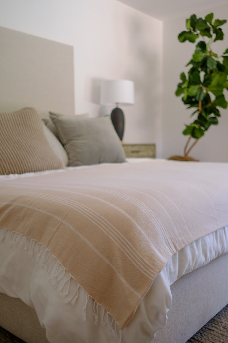 Beige colored Wetcat Turkish towel laying on the bed as a stylish throw