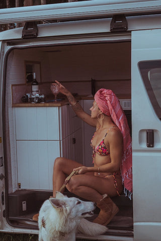 A traveler in a van using a Wetcat Turkish towel as a hair wrap